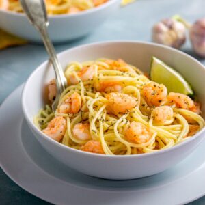 Espagueti con camarones al ajo servido en un bowl con limón