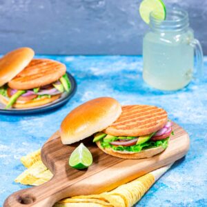 Hamburguesa de salmón a la plancha servida en pan brioche con aguacate, tomate y cebolla morada