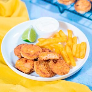 Nuggets de pescado dorados y crujientes servidos como refrigerio infantil con salsa para acompañar